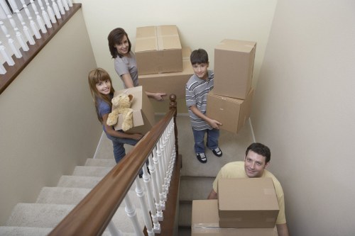 Moving team handling packed boxes and furniture in Kew