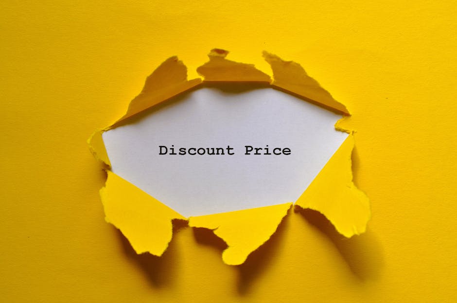 A close-up of a yellow paper sheet torn to reveal a white paper underneath, with the words 'Discount Price' printed in black. The torn edges of the yellow paper have a jagged appearance, and the background is also yellow, creating a contrast that highlights the message about pricing or discounts. This image is relevant to house removals and packing services offered by Man with Van Kew, illustrating the concept of special offers or cost-effective solutions for home relocation and furniture transport tasks.