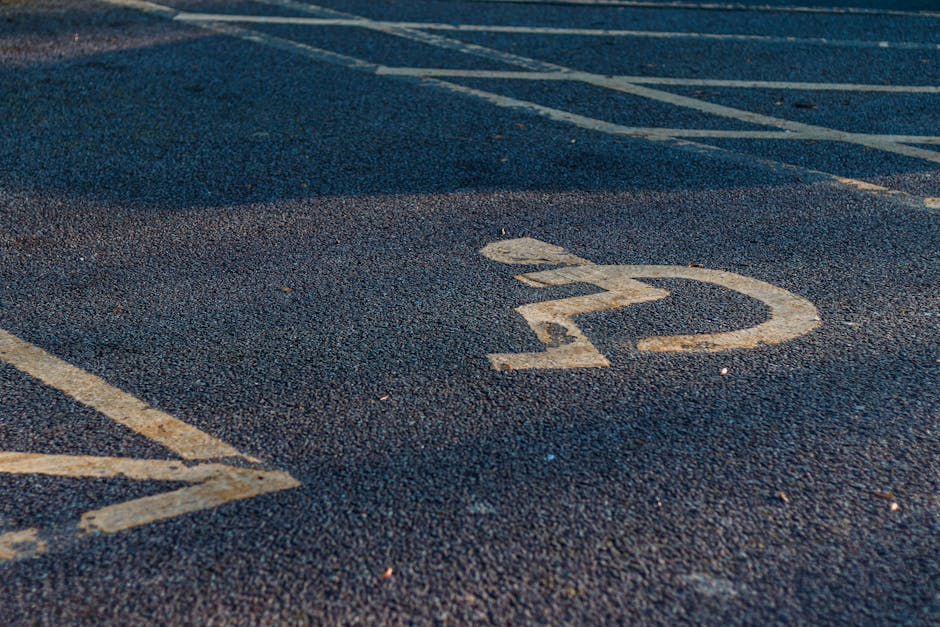 Close-up view of a numbered parking bay marked with a white number '22' painted on dark asphalt. The parking space is partially visible with adjacent lines indicating other parking bays. The surface appears slightly textured with minor debris. This image is taken outdoors, likely in a residential or commercial parking area used during house removals or furniture transport. The setting underscores the importance of proper parking access and planning for home relocation and moving services, such as those provided by Man with Van Kew, which may include advice on parking and van access for efficient load and unload processes.